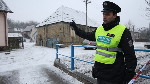 Policista hldkuje u domu v Doubravch na Zlnsku, kde byl tajn sklad zbran. (8. bezna 2012)