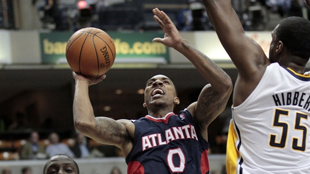 Jeff Teague z Atlanty se chystá ke stelb pes bránícího  Roye Hibberta z