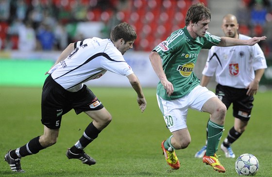 Tomá Borek (v zeleném) jet coby hrá Bohemians 1905 prochází hradeckou obranou.