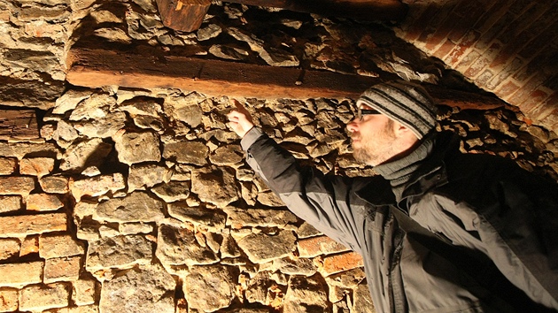 Archeolog Marek Peška ukazuje původní gotický trám ve sklepě budovy rekonstruované Základní umělecké školy v Jihlavě.