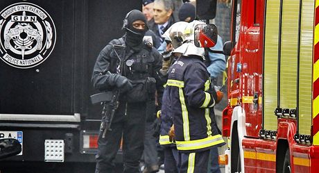 Francouzsk policista ze zsahov jednotky a hasii nedaleko domu, ve kterm se