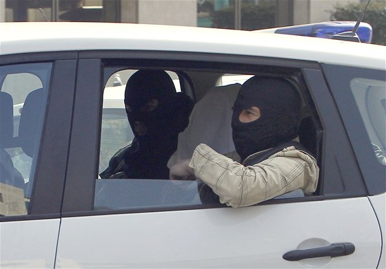 Neidentifikovaný muž sedící mezi členy protiteroristické jednotky, kterého