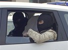 Neidentifikovaný muž sedící mezi členy protiteroristické jednotky, kterého