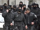 Maskovaní francouztí policisté opoutjí okolí obléhaného domu v Toulouse.