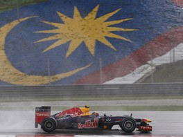 ZAMRAEN MALAJSIE. Mezi kapkami det se prohn Mark Webber s vozem Red Bull. 