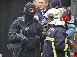 Francouzsk policista ze zsahov jednotky a hasii nedaleko domu, ve kterm se