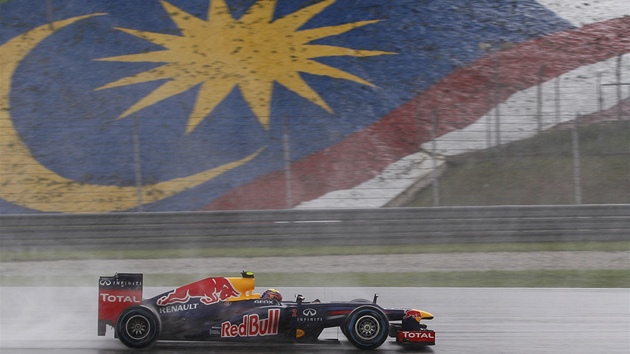 ZAMRAEN MALAJSIE. Mezi kapkami det se prohn Mark Webber s vozem Red Bull. 