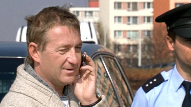 Podnapil Roman Janouek telefonuje u svho nabouranho vozu pot, co havaroval v Praze. (23. bezna 2012)
