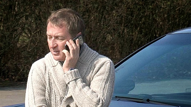 Podnapilý Roman Janoušek telefonuje u svého nabouraného vozu poté, co havaroval v Praze. (23. března 2012)