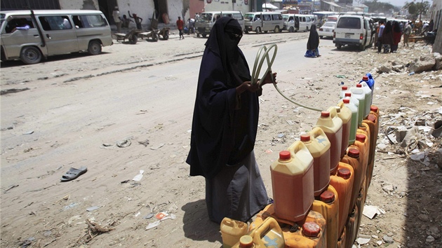 Somálka napluje benzínem kanistry, které hodlá prodat na trhu v Mogadiu (27.