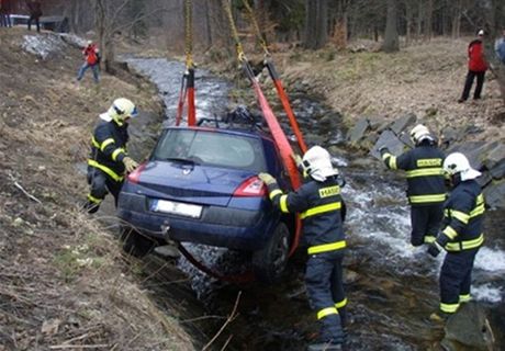 Hasii vytahují Renault Mégane z potoka v Karlov Studánce.