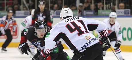 Martin koula z Omsku brání v semifinálovém duelu KHL Jevgenije Kuzncova z