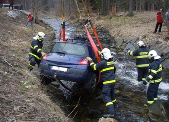 Hasii vytahují Renault Mégane z potoka v Karlov Studánce.