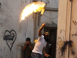 Protivládní demonstrant v Bahrajnu vrhá Molotovův koktejl proti policejním...