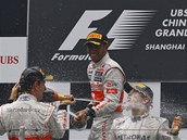 NEZBYTN SPRCHA. Jenson Button (vlevo) a Lewis Hamilton osvuj vtze Nico