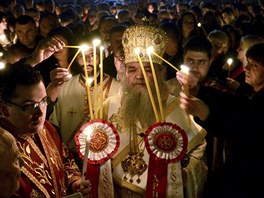 Patriarcha zapálí dva svazky 33 svící a zane rozdlovat svatý ohe davu...