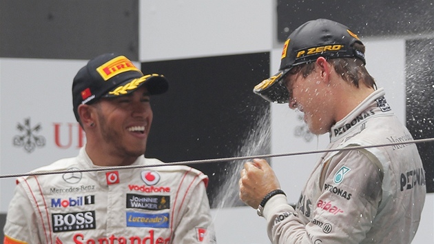 SDÍLENÁ RADOST. Lewis Hamilton sprchuje vítze Velké ceny íny Niko Rosberga.
