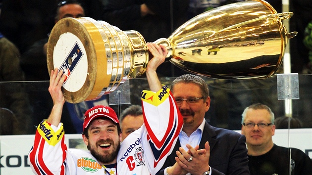 ŠŤASTNÝ KAPITÁN. Pardubický útočník Petr Koukal právě převzal pohár pro mistra hokejové extraligy. Koukal si užívá už třetích oslav titulu, celkem jich získaly Pardubice šest.