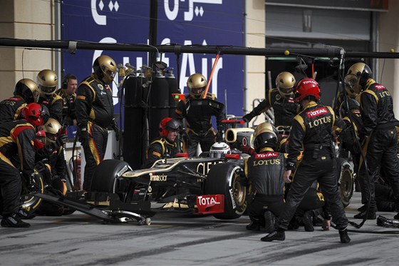 V BOXECH. Kimi Rikknen s mechaniky tmu Lotus pi zastvce v boxech.