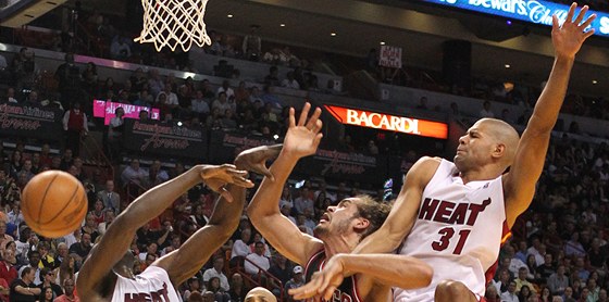 Joakim Noah (v tmavém) z Chicaga v miamském obklíení. Vlevo Joel Anthony,