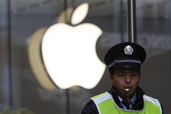 Policista stojící před čínským obchodem Apple