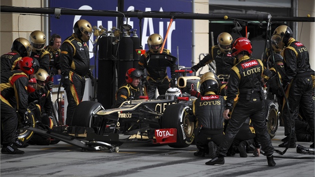 V BOXECH. Kimi Räikkönen s mechaniky týmu Lotus pi zastávce v boxech.