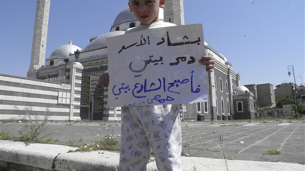 Syrský chlapec drí transparent s nápisem "Baár Asad mi zniil domov, mým