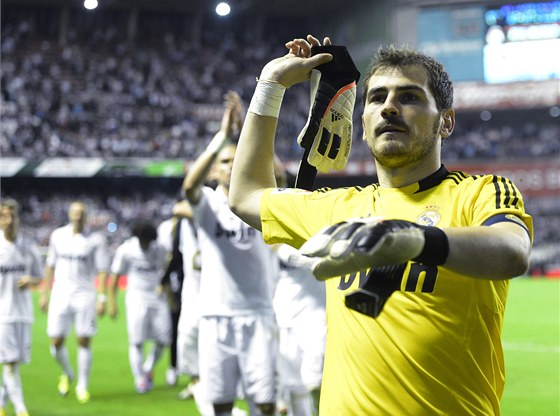 Branká Iker Casillas z Realu Madrid hází rukavice fanoukm poté, co jeho tým