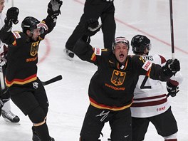 Němečtí hokejisté se radují ze vstřeleného gólu v zápase proti Lotyšsku.