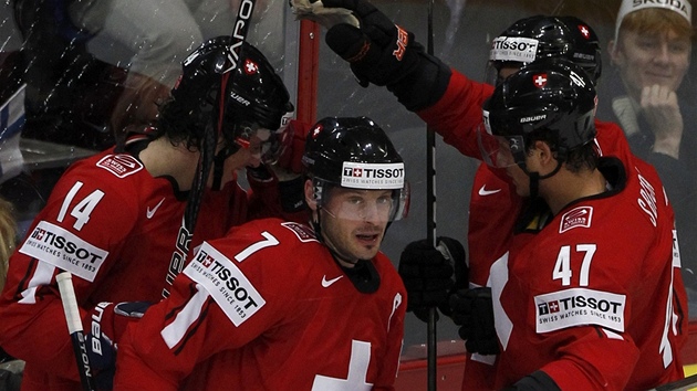 �výcar�tí hokejisté slaví gól a p�ekonaný finský branká� Kari Lehtonen pije z