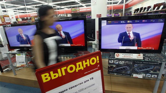 ena prochzejc kolem televizor s pmm penosem inauguran ceremonie Vladimira Putina (7. kvtna 2012)