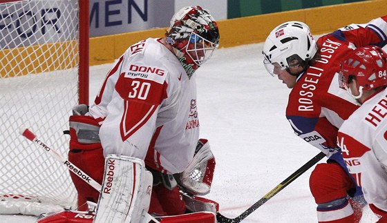 Norský hokejista Mats Rosseli Olsen  se dostává do ance ped dánského gólmana