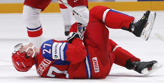 Alexej Treenko z Ruska leí na led poté, co ho eský reprezentant Petr