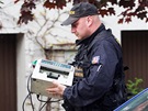 Policista pináí poítaku penz do domu Davida Ratha v Hostivici (15. kvtna...