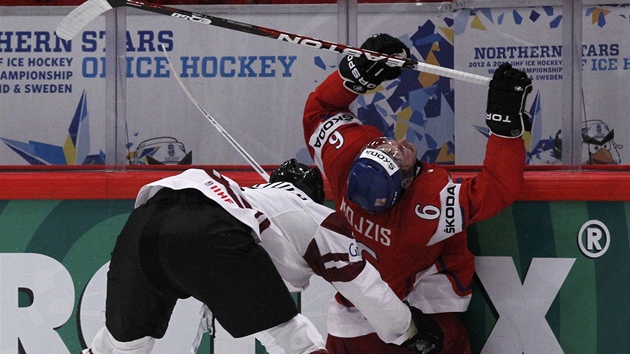 VRAENÍ NA HRAZENÍ. Lotyský hokejista Oskars Bartulis tvrd atakuje u
