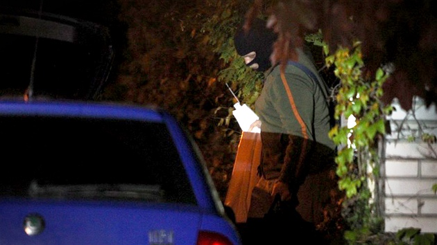 Kriminalisté odváejí dkazy z domu Davida Ratha v Hostivici (15. kvtna 2012).