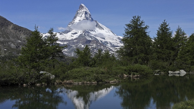 Právě od jezera Grindjisee pocházejí oblíbené pohlednice se zrcadlovým odrazem Matterhornu ve vodní hladině mezi stromy.
