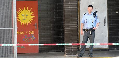 Policista hlídá u jednoho ze vchod do Základní koly Moravská v