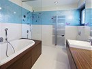 Koupelna dcery. Modrobílá mozaika elegantn kontrastuje s teakovým devem....