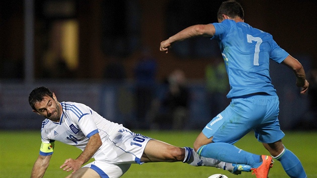 TVRÁK. Karagounis (vlevo) z ecka zastavuje ostrým skluzem Slovince Sisice.