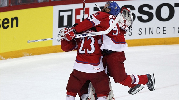 DOBOJOVÁNO! Petr Nedvěd (vpravo) skočil na brankáře Jakuba Štěpánka a čeští hokejisté slaví zisk broznových medailí.