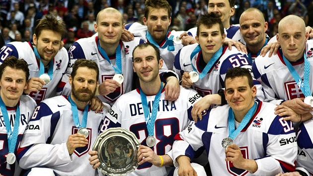 STŘÍBRO DO NEBE. Slovenští hokejisté v dresech se jménem Pavola Demitry pózují fotografům s pohárem pro druhý celek mistrovství světa. 