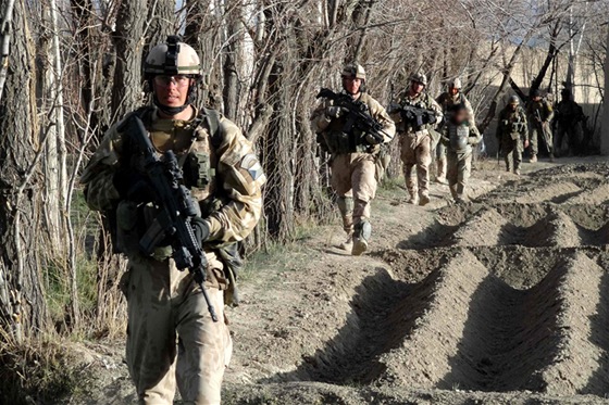 ei postupují pi okraji pole bhem operace Welcome Home, v pozadí za nimi písluníci afghánské národní armády. Ilustraní snímek