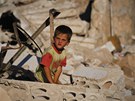 Syrský chlapec sedí v troskách dom, který byl znien bhem boj mezi opozicí a