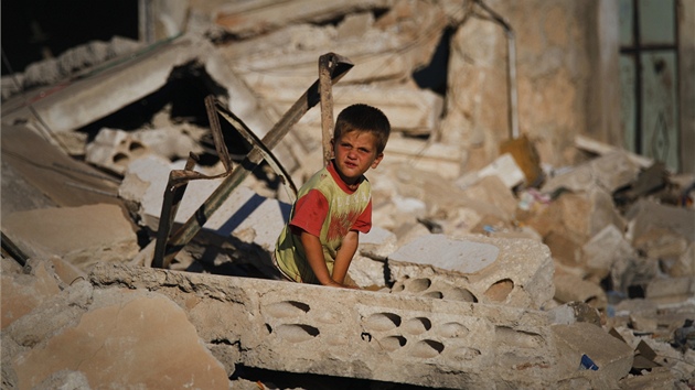 Syrský chlapec sedí v troskách dom, který byl znien bhem boj mezi opozicí a