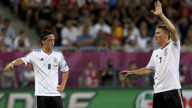JÁ TO KOPNU. Nmetí fotbalisté Mesut Özil a Bastien Schweinsteiger se
