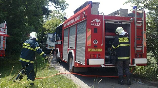 Policist a hasii v praskch Cholupicch, kde bylo v hocm aut nalezeno tlo eny. 