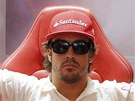 EKÁNÍ. panlský jezdec Fernando Alonso sedí a vykává mezi leny svého týmu.