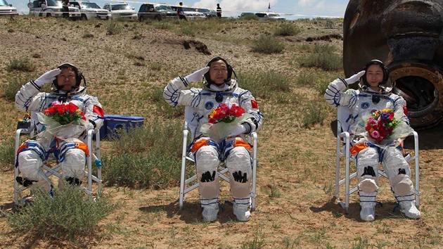 Zleva kosmonauti Liu Wang, velitel lodi Jing Haipeng a vpravo první čínská astronautka Liu Yang zdraví po úspěšném návratu na Zem v pátek 29. června 2012.
