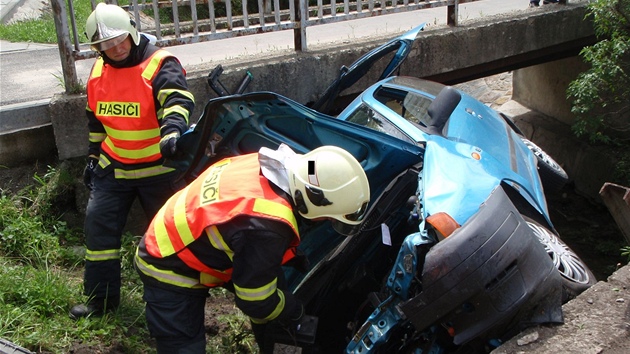 Hasii vyproují automobil napasovaný v koryt potoka ve zlínské ásti Louky.